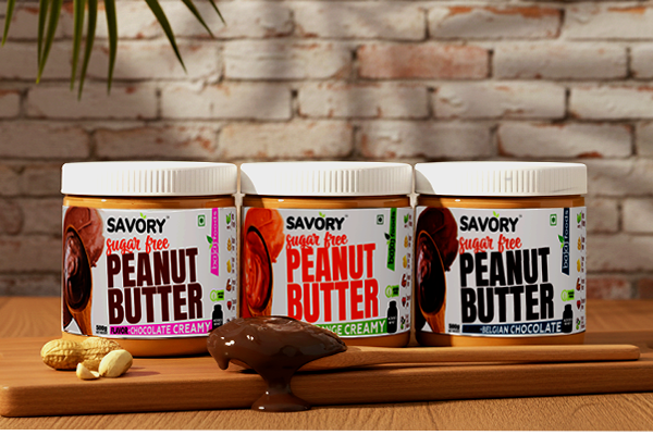 Three jars of Savory Peanut Butter on a wooden board with a brick wall background